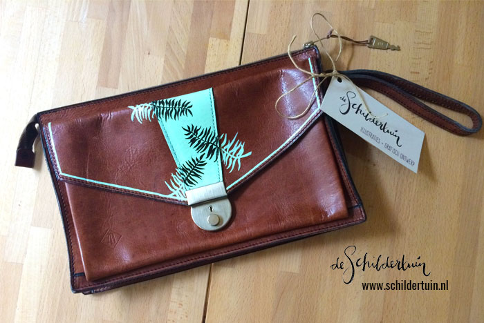 foto van een handgeschilderde leren tas met botanische illustratie