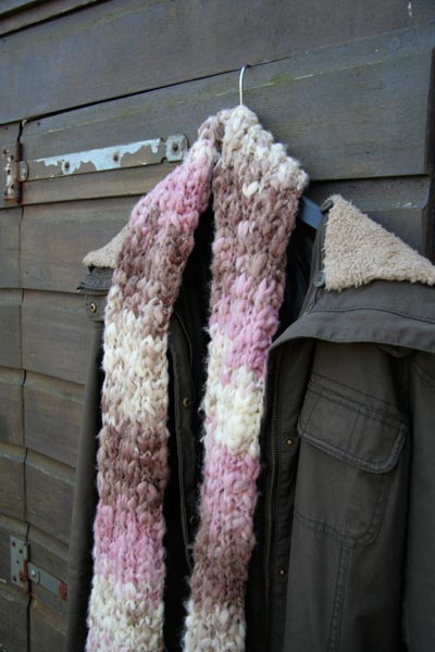 Foto van een zelf gebreide sjaal bij een winterjas