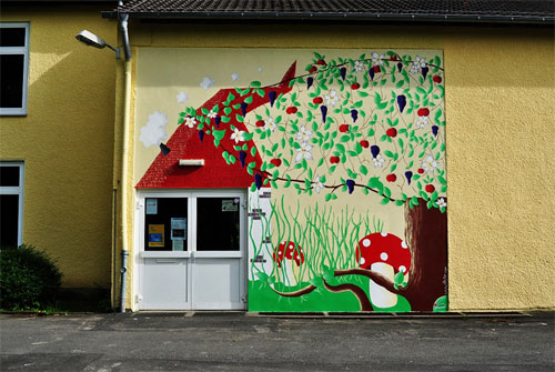 muurschildering van Britta Reinhard met kabouterhuis, paddestoelen en boom